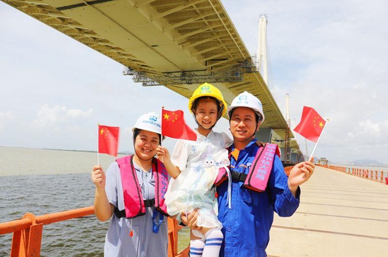 图五为员工黄晨领着妻子、女儿到工地看大桥的情景。1