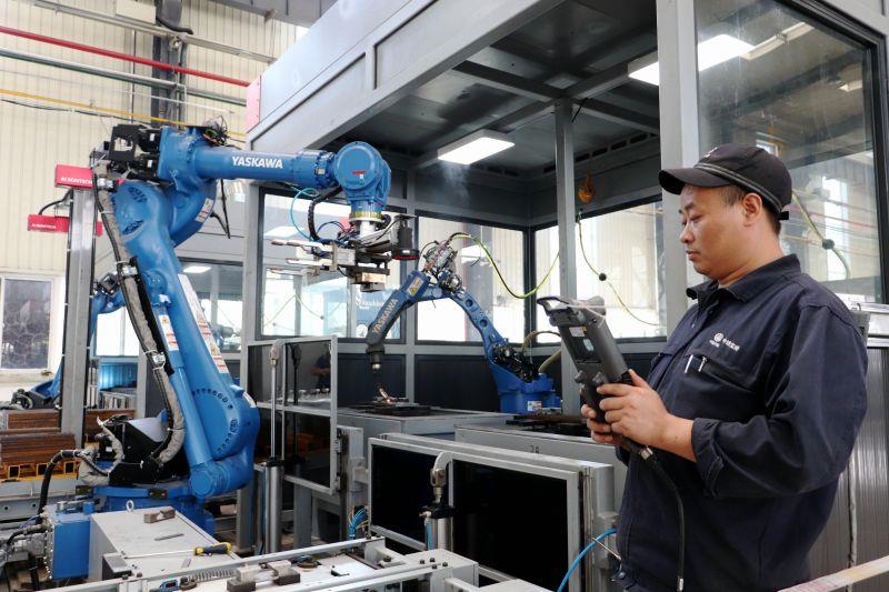 宝桥职工正在操控机器人进行道岔垫板焊接作业