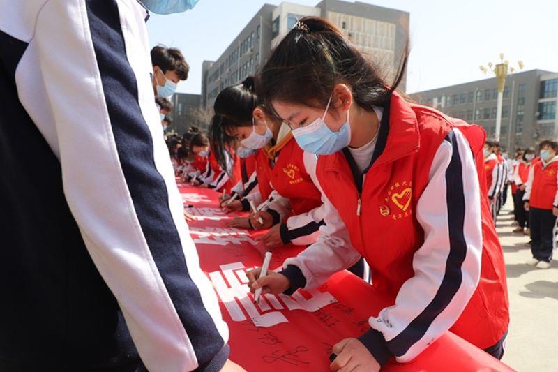 中铁国资郑铁学院团委举办雷锋活动月启动仪式，图为学生签字环节