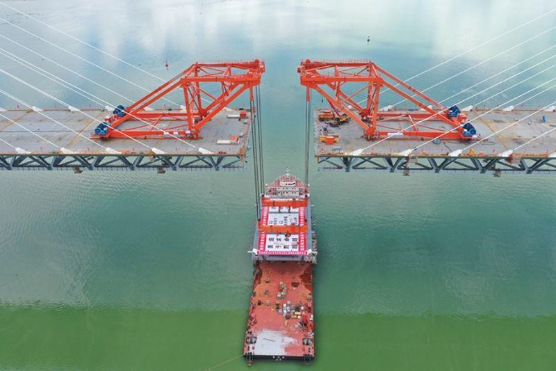 图为大桥最后一节钢桁梁吊装